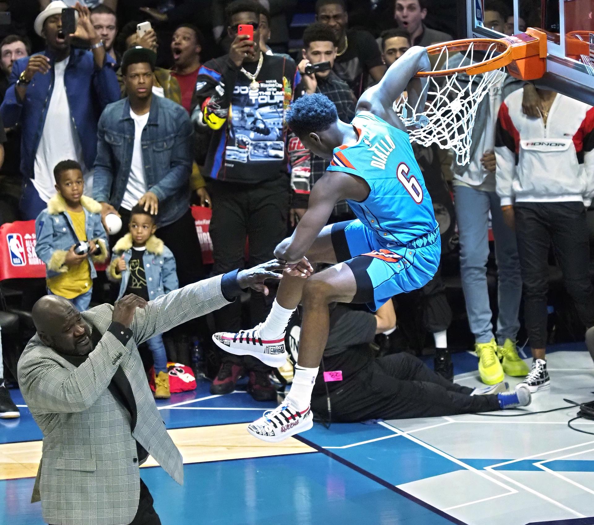 Hamidou Diallo (D), entonces salta sobre Shaquille O'Neal y machaca el aro, durante el concurso de mates de la NBA que se adjudicó en 2019. EFE/EPA/JOHN G MABANGLO