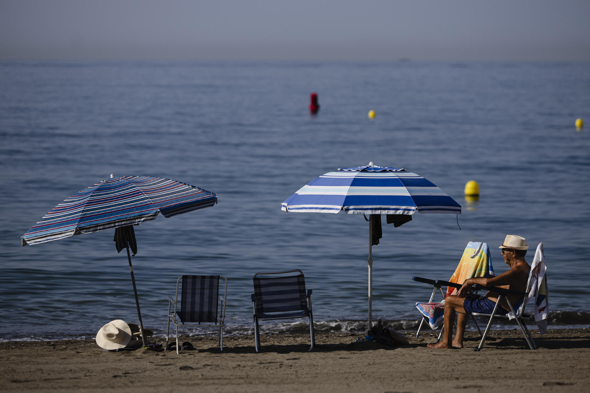 Un hombre sentado junto al mar en la playa del Rincón de la Victoria (Málaga), este miércoles. EFE/Jorge Zapata