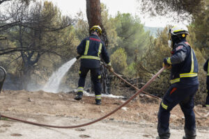 Dos bomberos en labores de extinción del incendio declarado este miércoles en la Urbanización Las Marías de Torrelodones, en Madrid. EFE/ J.P.Gandul