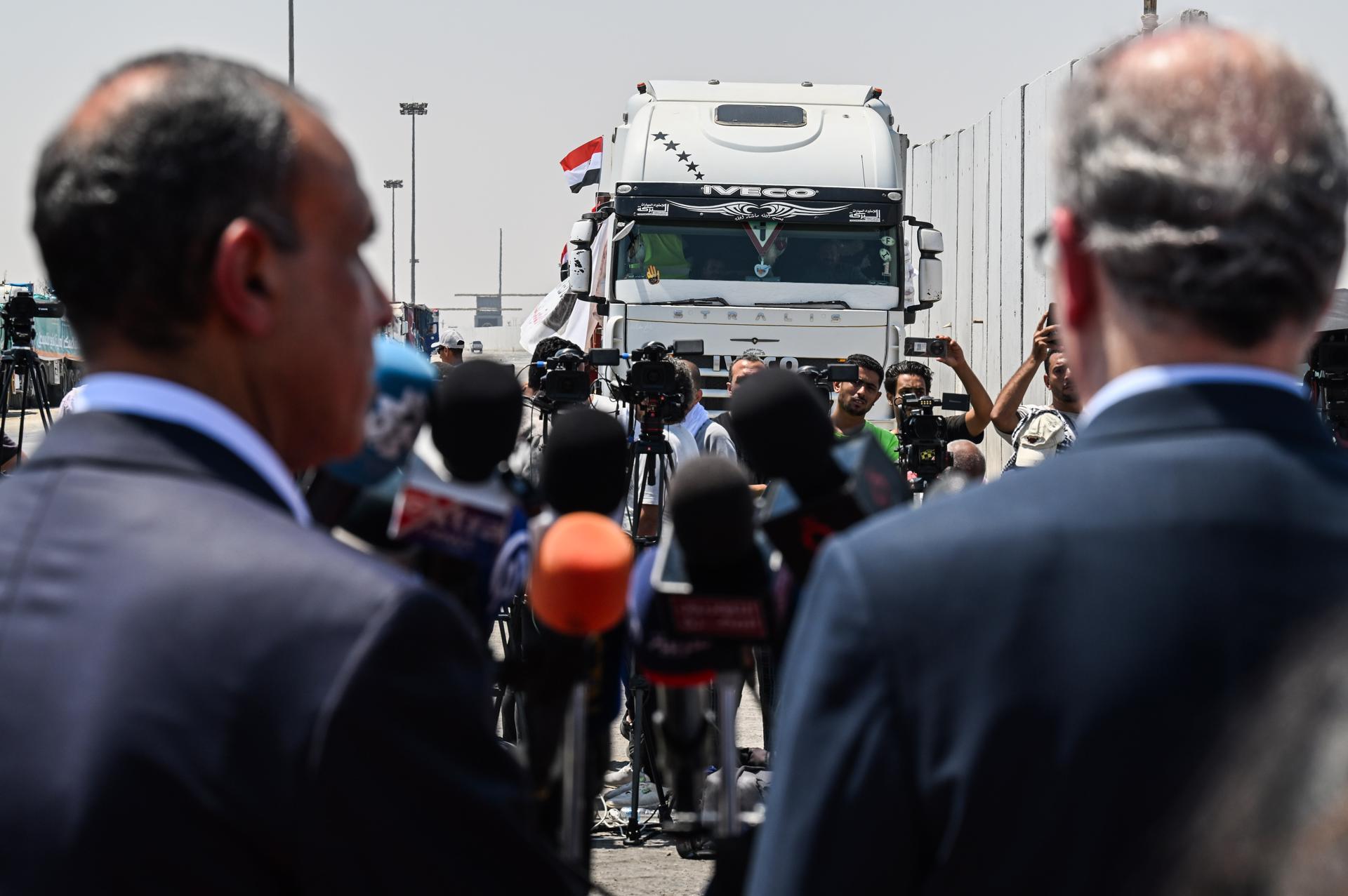 Un camión (trasero) cargado con ayuda humanitaria con destino a Gaza espera cerca del cruce fronterizo de Rafah, entre Egipto y la Franja de Gaza, mientras el ministro de Asuntos Exteriores egipcio, Badr Abdelatty (izq.), y el primer ministro palestino, Mohamed Mostafa (der.), ofrecen una conferencia de prensa conjunta, en Rafah, Gobernación de Sinaí del Norte, Egipto, el 18 de agosto de 2025.(Egipto) EFE/EPA/MOHAMED HOSSAM

