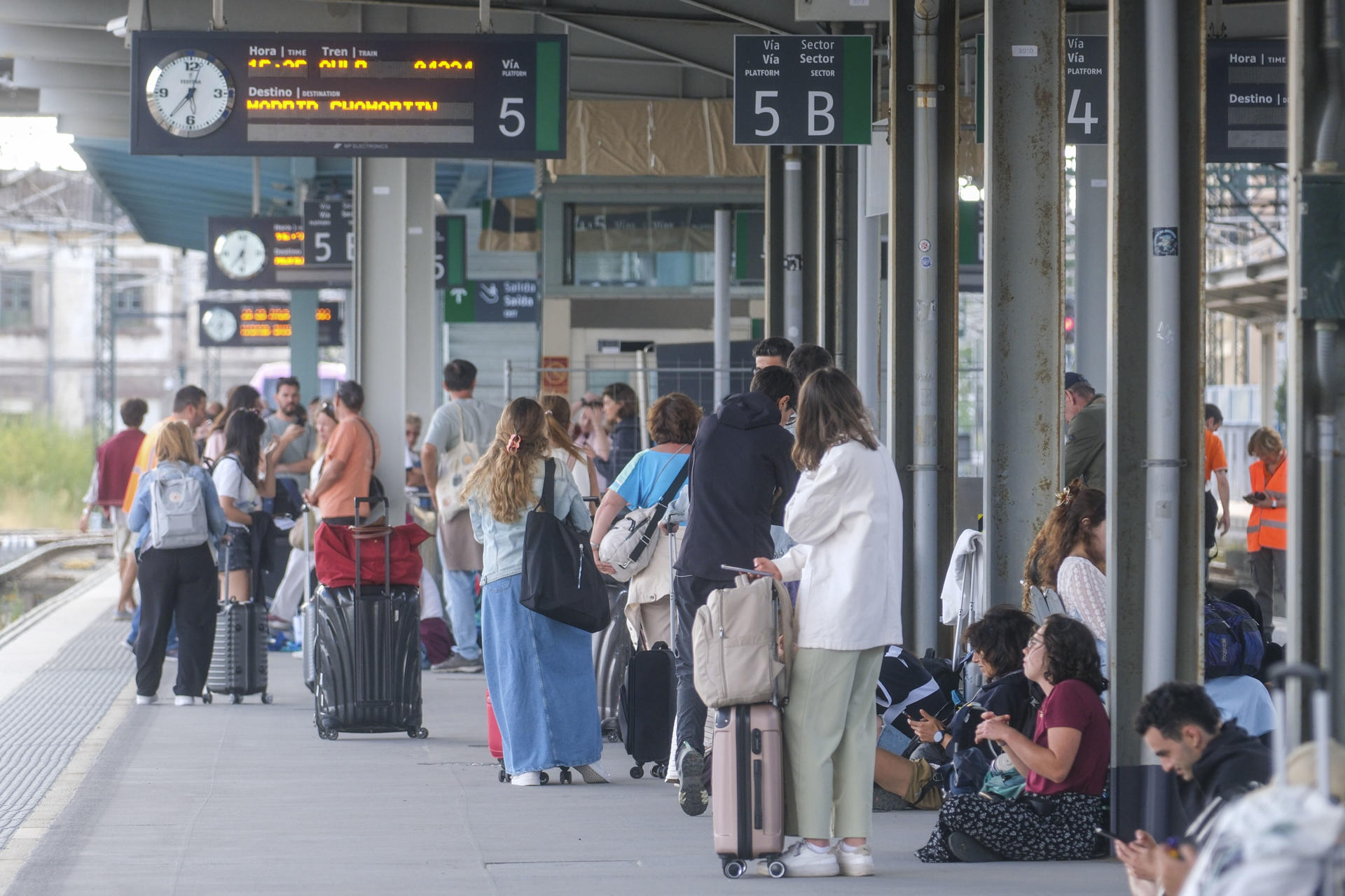 Viajeros esperan para embarcar en sus trenes este miércoles, cuando se ha reestablecido la circulación en tren entre Santiago de Compostela y Madrid, que había permanecido cortada por los incendios. EFE/ Xurxo Martínez
