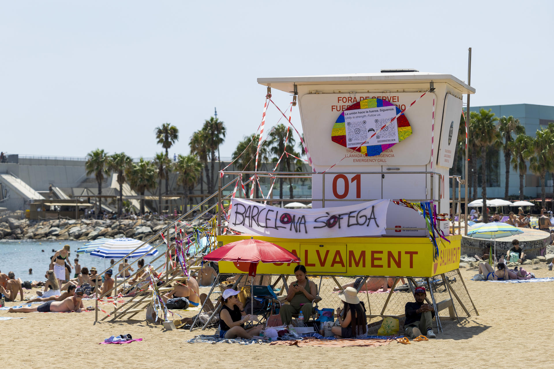 Mensajes de "Barcelona se ahoga" o "Estamos ahogados2 cuelgan de las casetas de socorrismo en las playas de Barcelona durante la huelga de socorristas este domingo, que está teniendo lugar estos días donde se reclama más derechos para los trabajadores. EFE/Marta Pérez