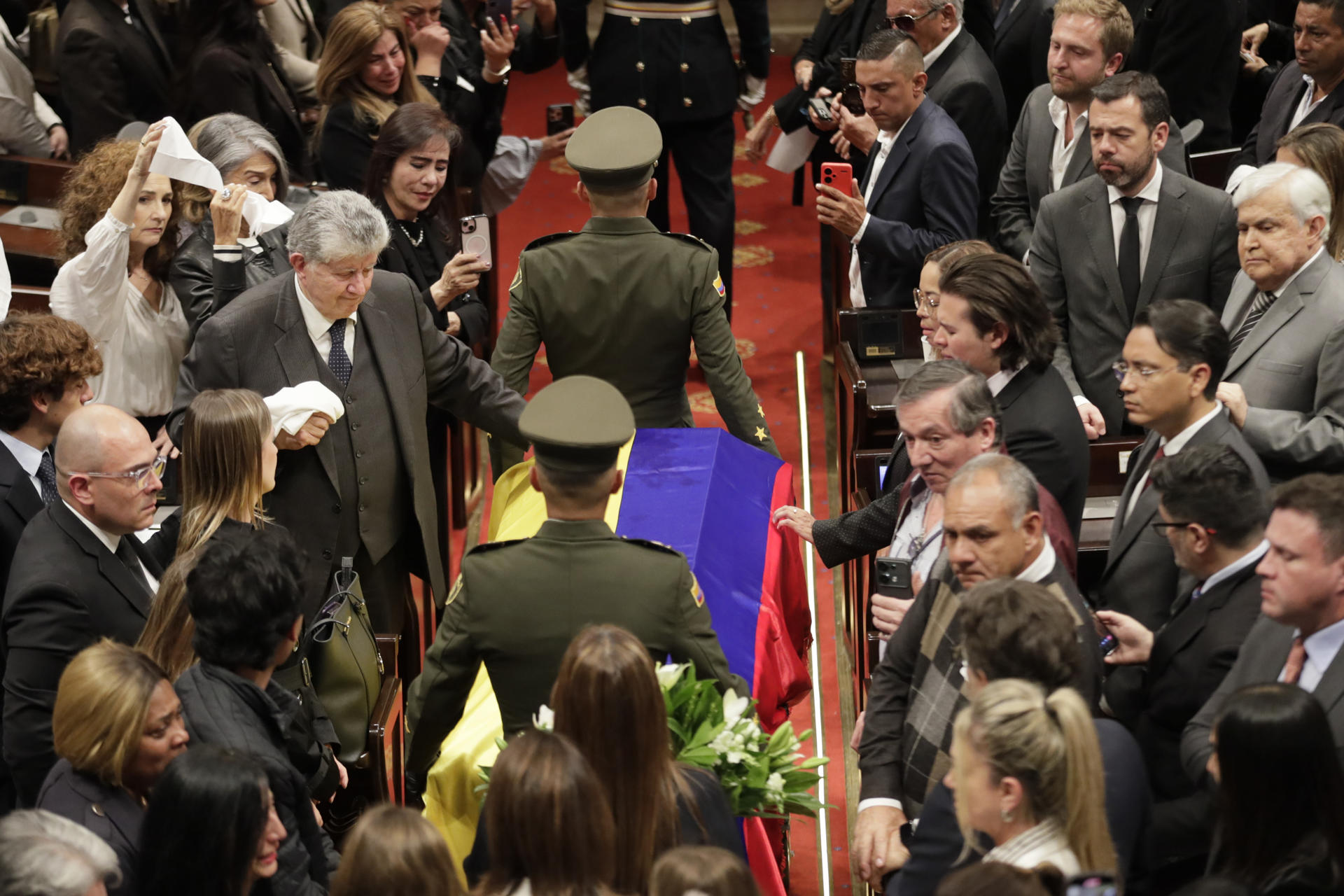 Julio César Turbay Quintero (c-i) toca el féretro de su sobrino el fallecido senador y precandidato a la presidencia de Colombia Miguel Uribe Turbay este lunes, en Bogotá (Colombia). EFE/ Carlos Ortega