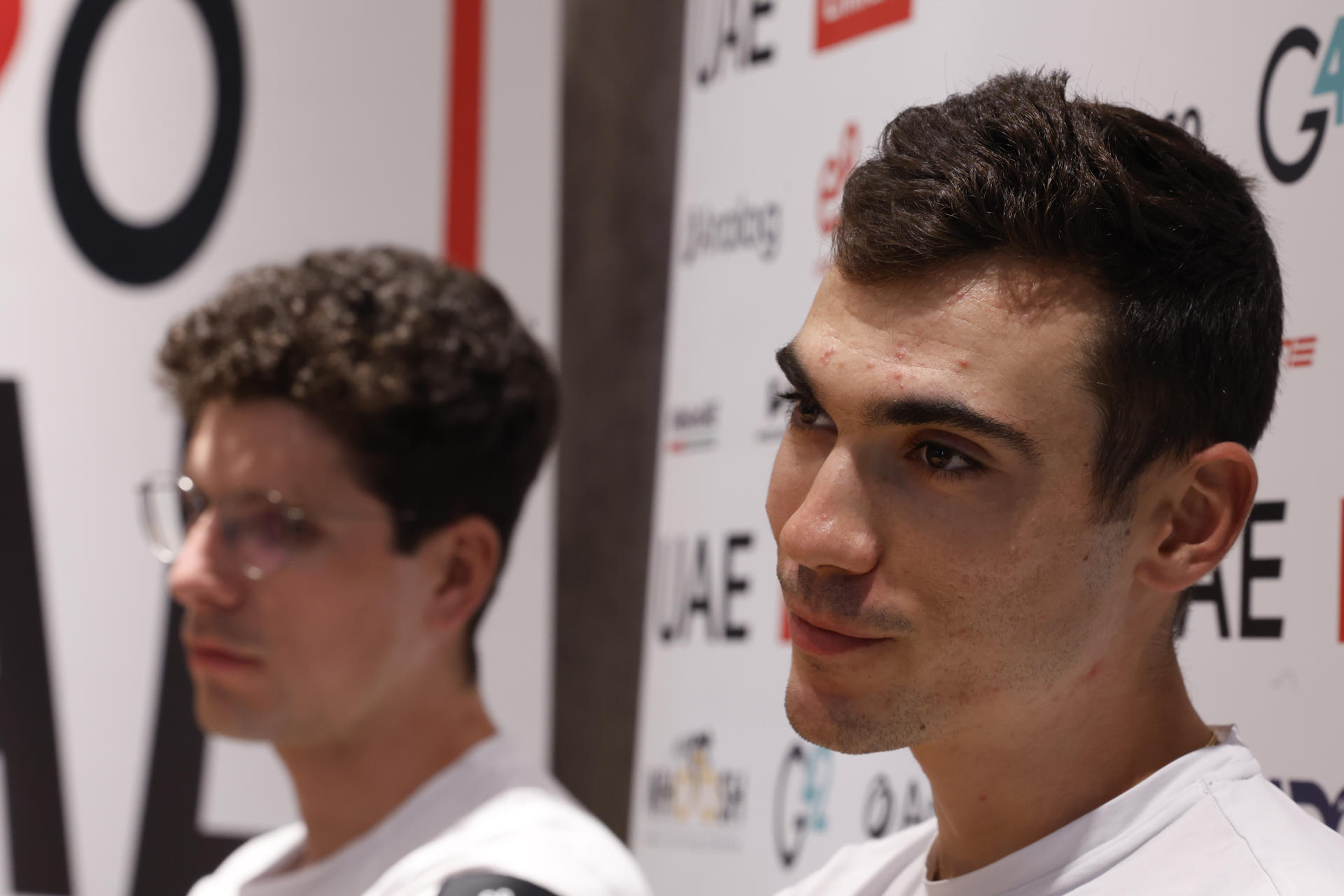 El ciclista español del UAE Team Emirates Juan Ayuso (d) junto a su compañero portugués Joao Almeida durante una comparecencia este jueves en Turín, donde el sábado comienza la Vuelta a España 2025. EFE/ Javier Lizón
