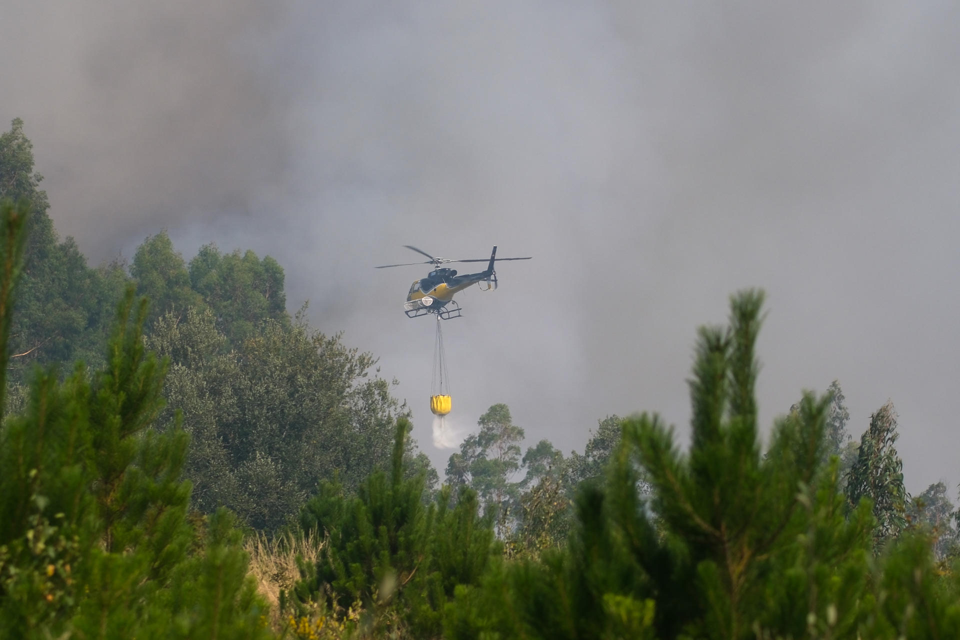 Un helicóptero realiza labores de extinción en un incendio en Penagundín, en Melide (A Coruña), el pasado día 15. EFE/ Xurxo Martínez