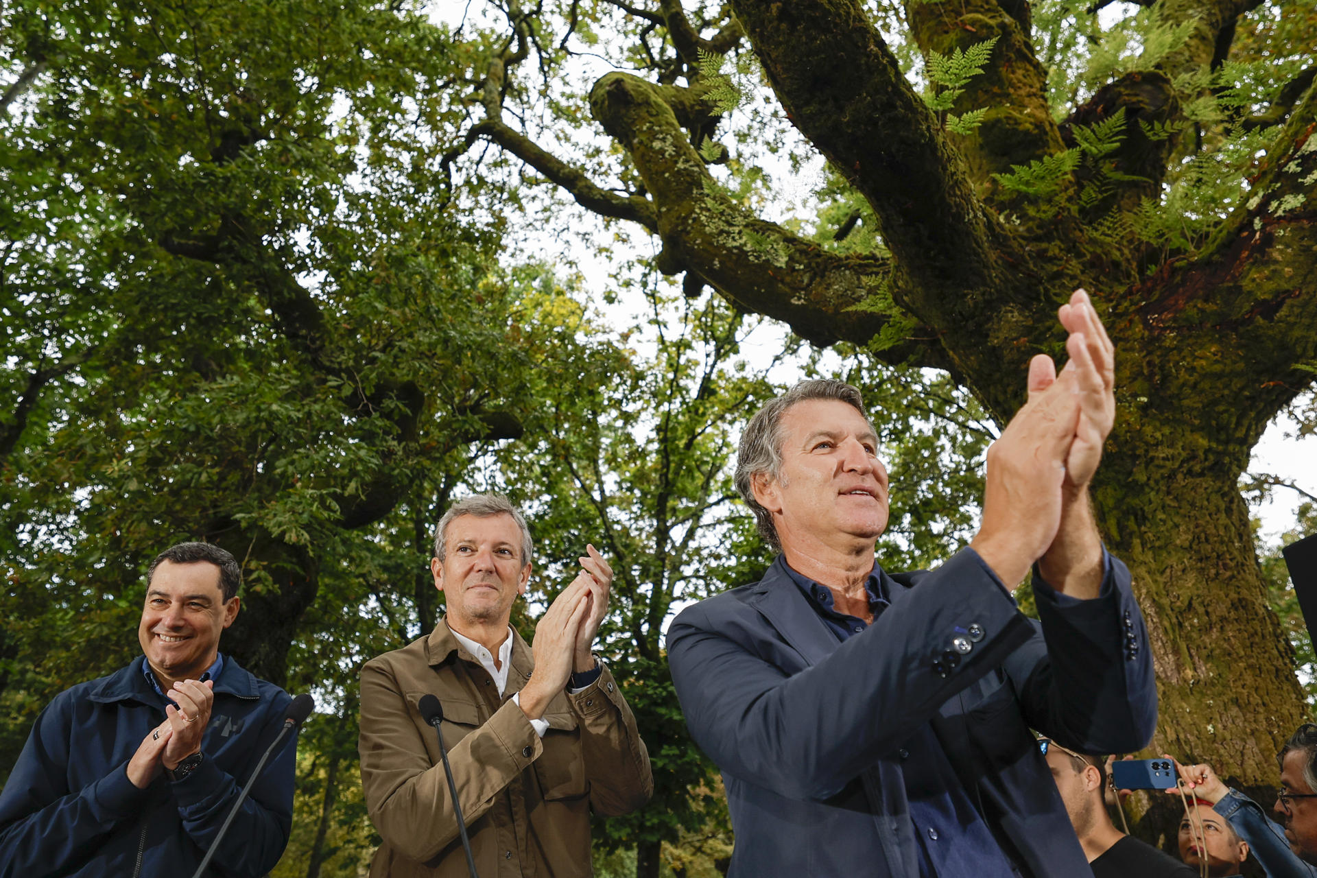 El líder del PP, Alberto Núñez Feijóo (d), el presidente de la Xunta de Galicia, Alfonso Rueda (c), y el presidente de la Junta de Andalucía, Juanma Moreno (i), asisten al acto de inauguración de la temporada política este domingo en la localidad pontevedresa de Cerdedo-Cotobade. EFE/ Lavandeira Jr
