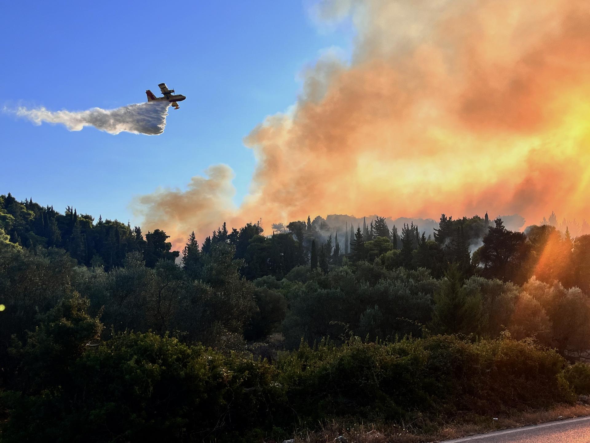 .- Imagen de este martes de una persona observa un incendio forestal en una zona montañosa entre Potamia y Pispilounta este martes, en la isla de Quíos (Grecia). EFE/EPA/ Kostas Kourgias