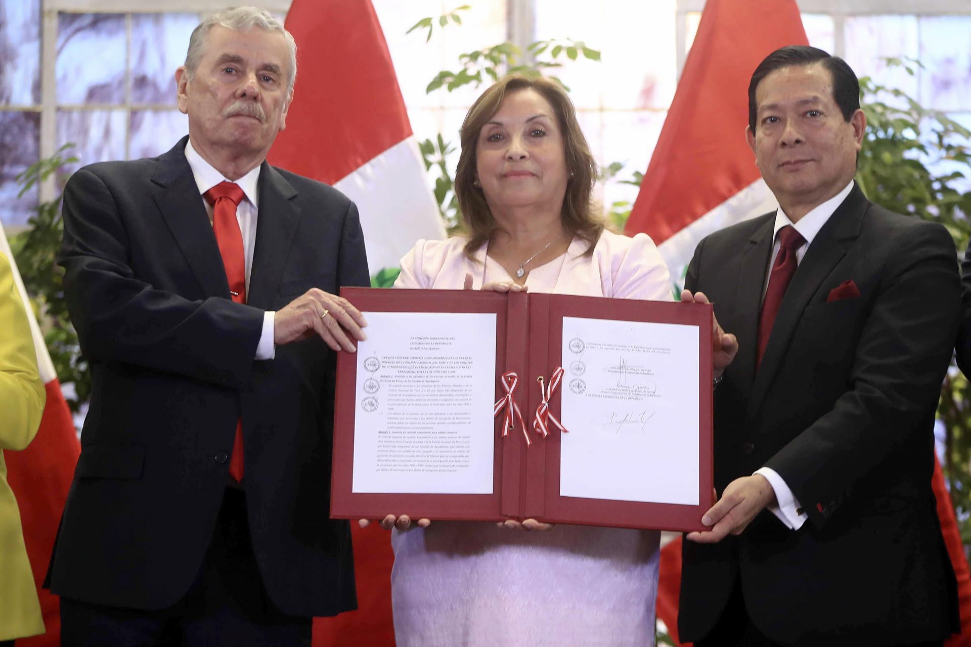 Fotografía cedida por la Presidencia de Perú de la mandataria, Dina Boluarte (c), el congresista Fernando Rospigliosi (i) y el primer ministro, Eduardo Aarana, posando con la firma del documento de amnistía este miércoles, en el Palacio de Gobierno en Lima (Perú). EFE/ Presidencia de Perú