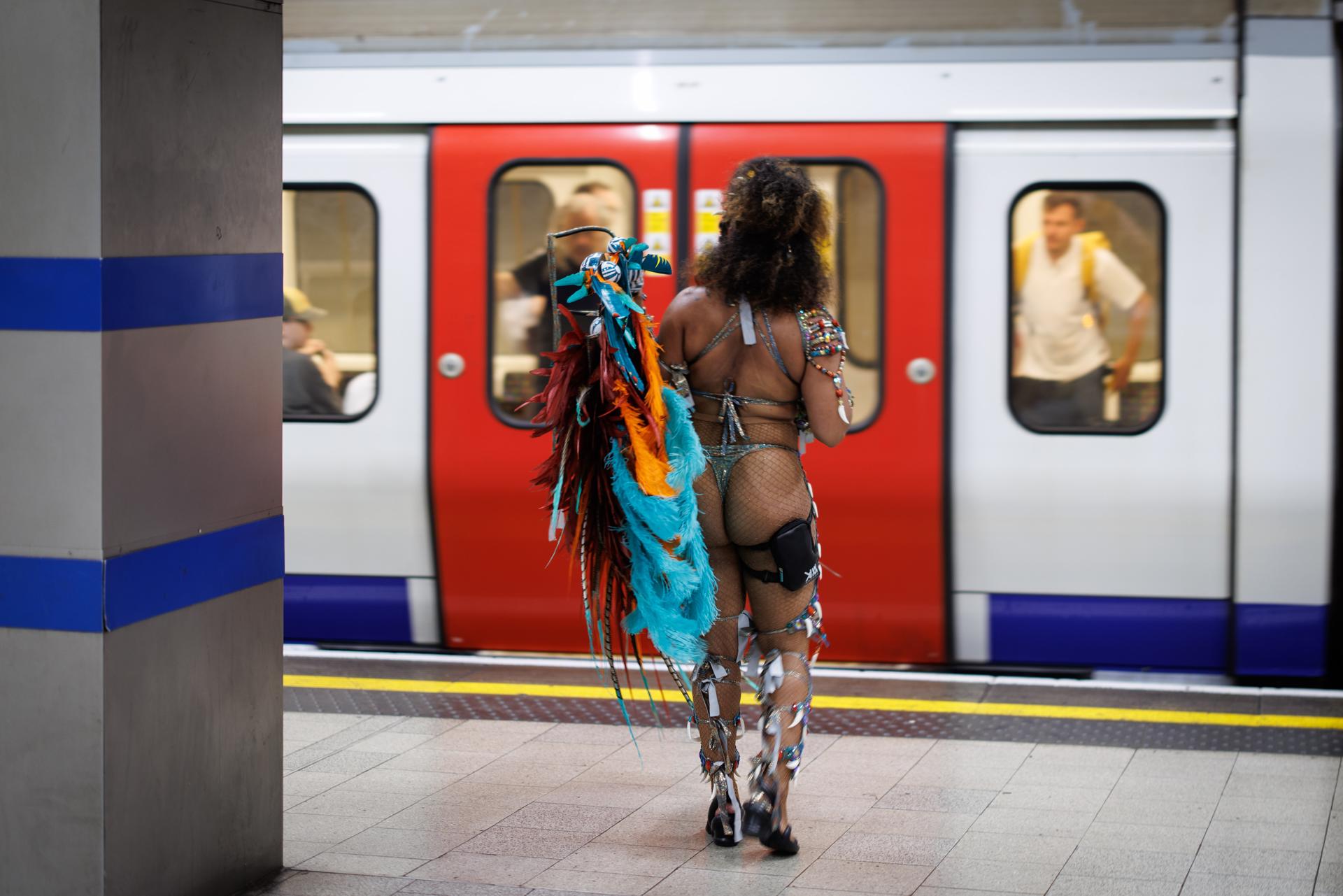 Un participante del Carnaval de Notting Hill se desplaza en el metro al desfile este lunes. EFE/TOLGA AKMEN