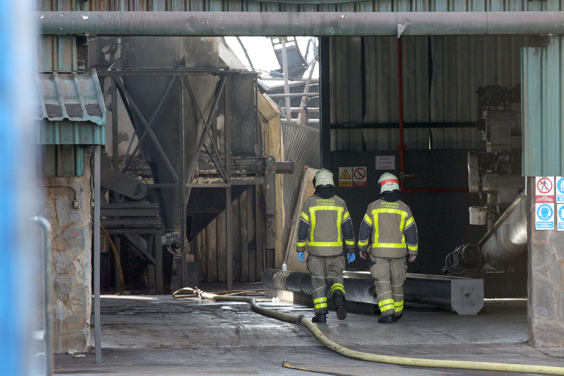 Bomberos trabajan en la extinción de un incendio en la fábrica de Aceites Sierra Sur, en el que fallecieron dos trabajadores en la madrugada de este domingo, en la localidad Granadina de Pinos Puente, cuyo ayuntamiento ha decretado tres días de luto oficial y ha suspendido sus fiestas de agosto. EFE/ Pepe Torres