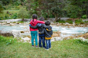 Fotografía del 18 de octubre de 2021 cedida por Unicef donde se observa a tres niños que fueron deportados de Estados Unidos esperando junto a un río en Chiantla, Huehuetenango (Guatemala).EFE/ Patricia Willocq / Unicef /