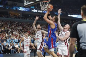 Losletones Rihards Lomazs (I), Arturs Kurucs y Rolands Smits tratan de frenar al serbio Nikola Jokic en el partido del EuroBasket jugado en Riga, Letonia. EFE/EPA/TOMS KALNINS