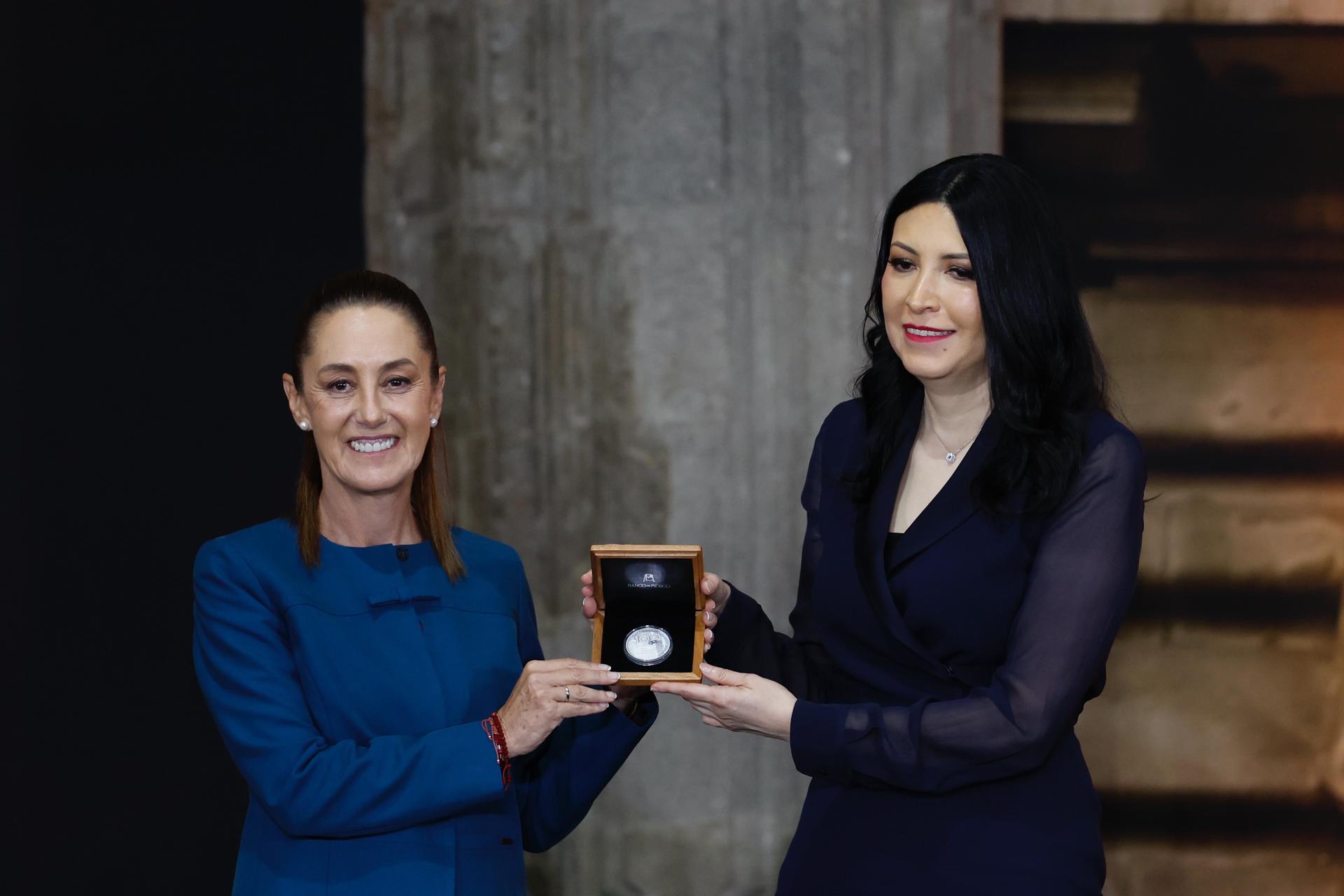 La presidenta de México, Claudia Sheinbaum (i), y la gobernadora del Banco de México (Banxico), Victoria Rodríguez, posan con una placa conmemorativa del 100 aniversario de la fundación de Banxico este lunes, en Ciudad de México (México). EFE/ Sáshenka Gutiérrez