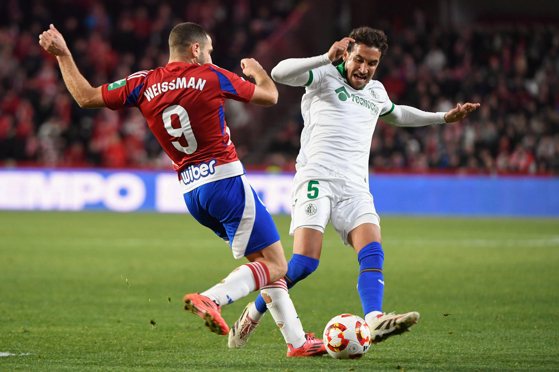 Foto de archivo del delantero israelí del Granada Shon Weissman (i), peleando un balón con el centrocampista del Getafe CF Luis Milla (d) durante un partido de la Copa del Rey. EFE/ Miguel Ángel Molina