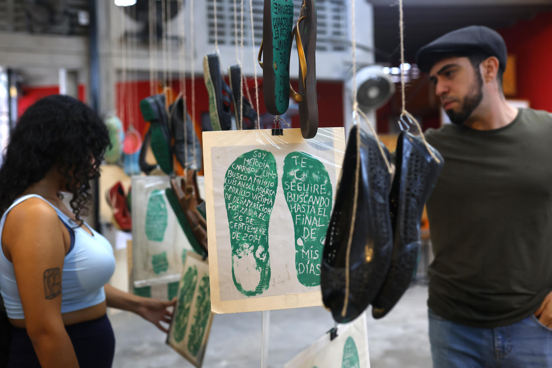 Personas leen carteles en la muestra 'Huellas de la Memoria' este sábado, en Guadalajara (México). EFE/ Francisco Guasco
