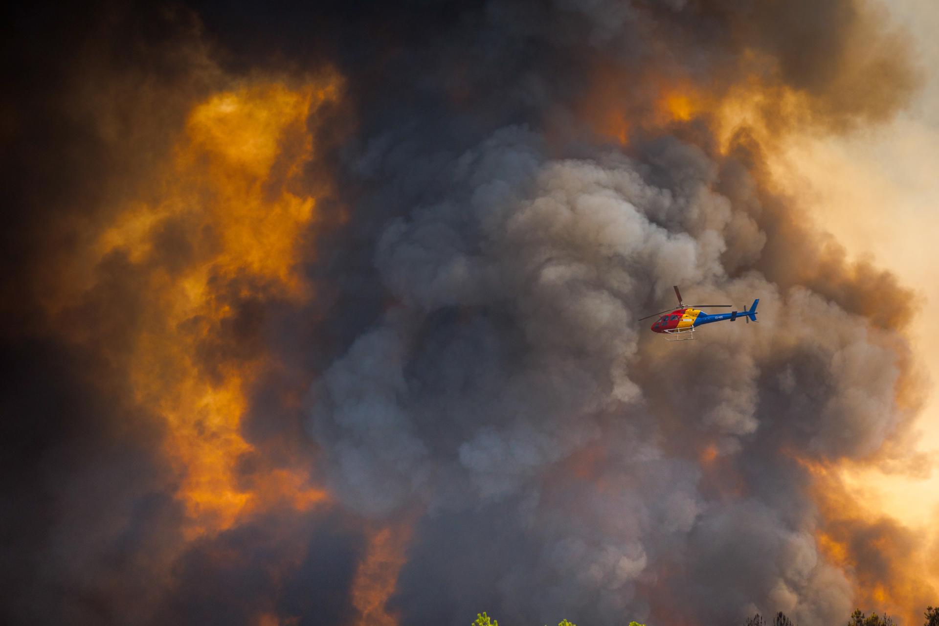 Un helicóptero sobrevuela la zona en llamas de Granjal, Sernancelhe, Viseo, Portugal. EFE/EPA/PEDRO SARMENTO COSTA