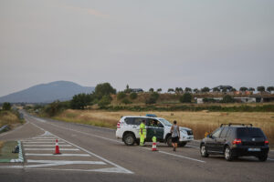 Una patrulla de la Guardia Civil controla el acceso a una carretera debido al incendio que se originó ayer en Navalmoralejo. EFE/ Manu Reino