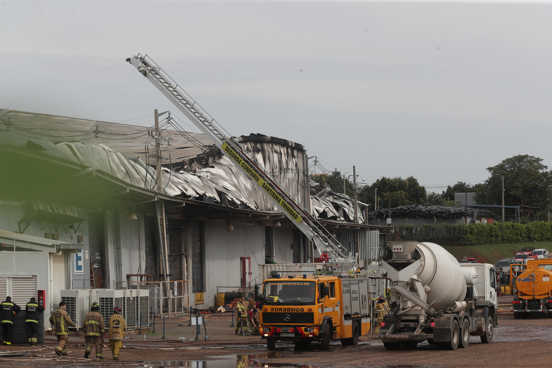 Integrantes del cuerpo de bomberos de Paraguay intentan apagar un incendio este domingo, en el Parque Industrial Logístico Nuestra Señora de la Asunción, en Luque (Paraguay). EFE/ Juan Pablo Pino