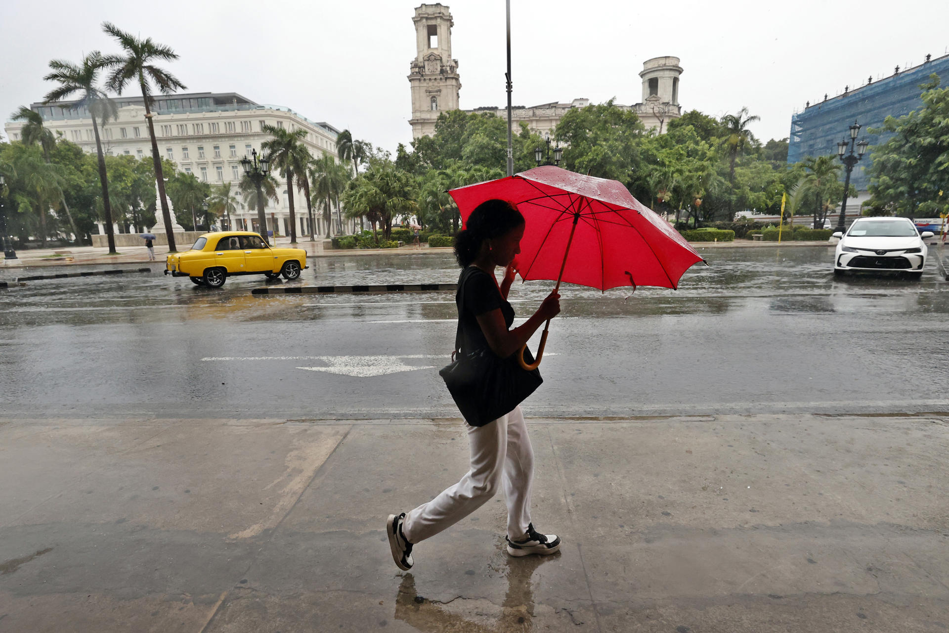 Una mujer camina bajo la lluvia en La Habana (Cuba), en una fotografía de archivo. EFE/ Ernesto Mastrascusa