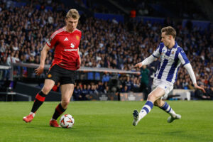 El delantero danés Rasmus Hojlund (i) ante Beñat Turrientes, durante el partido que disputó el Manchester United frente a la Real Sociedad, de octavos de final la Liga Europa, en el Real Arena de San Sebastián. EFE/ Javier Etxezarreta