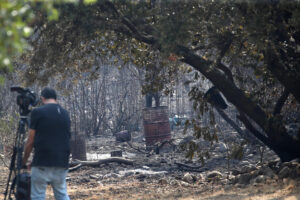 Un reportero toma imágenes tras el paso del incendio. EFE/Ana F. Barredo