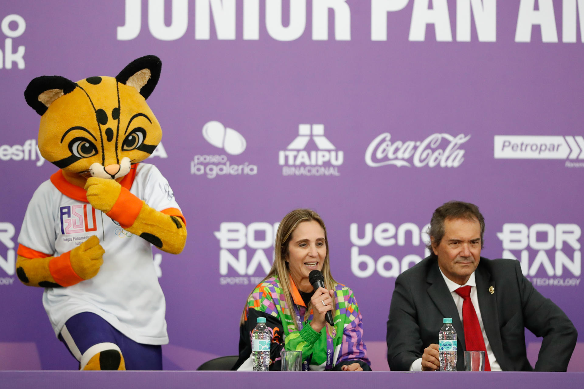 La directora adjunta de los Juegos Panamericanos Junior Asunción 2025, Larissa Schaerer (c), habla junto al presidente de Panam Sports, Neven Ilic. EFE/Juan Pablo Pino