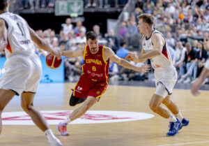 El escolta de España Darío Brizuela (c) supera al base de Alemania Justus Hollatz (d) durante el partido amistoso preparatorio para el Eurobasket 2025 celebrado este sábado en el Lanxess Arena de Colonia. EFE/FEB/Alberto Nevado