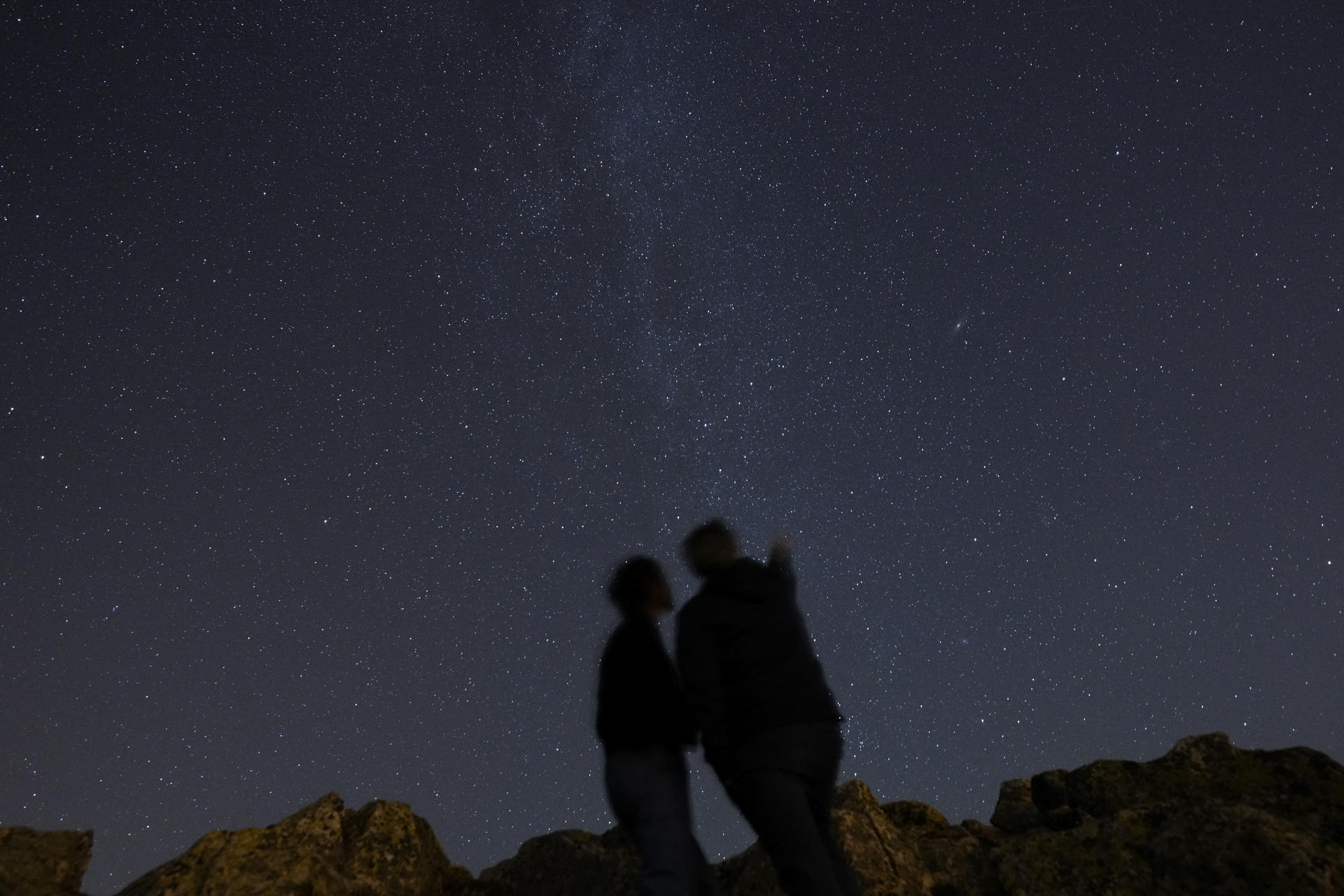Imagen de archivo (13/08/2023) de dos personas observando el cielo para observar alguna estrella fugaz en la madrileña sierra de Guadarrama.
EFE/ Borja Sánchez-Trillo
