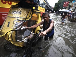 MANILA (Filipinas), 22/08/2025.- Filipinos atraviesan inundaciones en una carretera en Manila, Filipinas, el 22 de agosto de 2025, causadas por una depresión tropical acompañada de vientos de hasta 90 kilómetros por hora. EFE/EPA/FRANCIS R. MALASIG