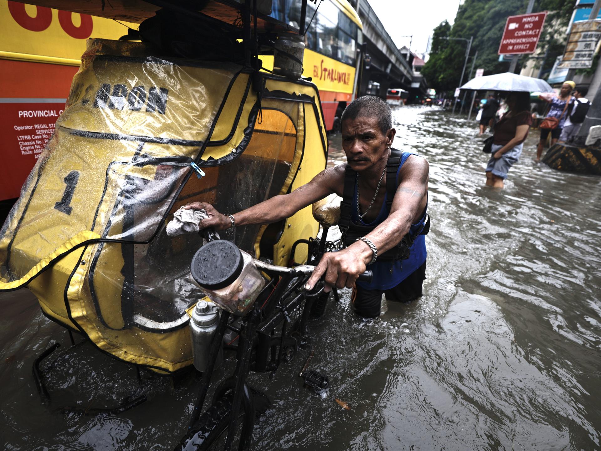 MANILA (Filipinas), 22/08/2025.- Filipinos atraviesan inundaciones en una carretera en Manila, Filipinas, el 22 de agosto de 2025, causadas por una depresión tropical acompañada de vientos de hasta 90 kilómetros por hora. EFE/EPA/FRANCIS R. MALASIG
