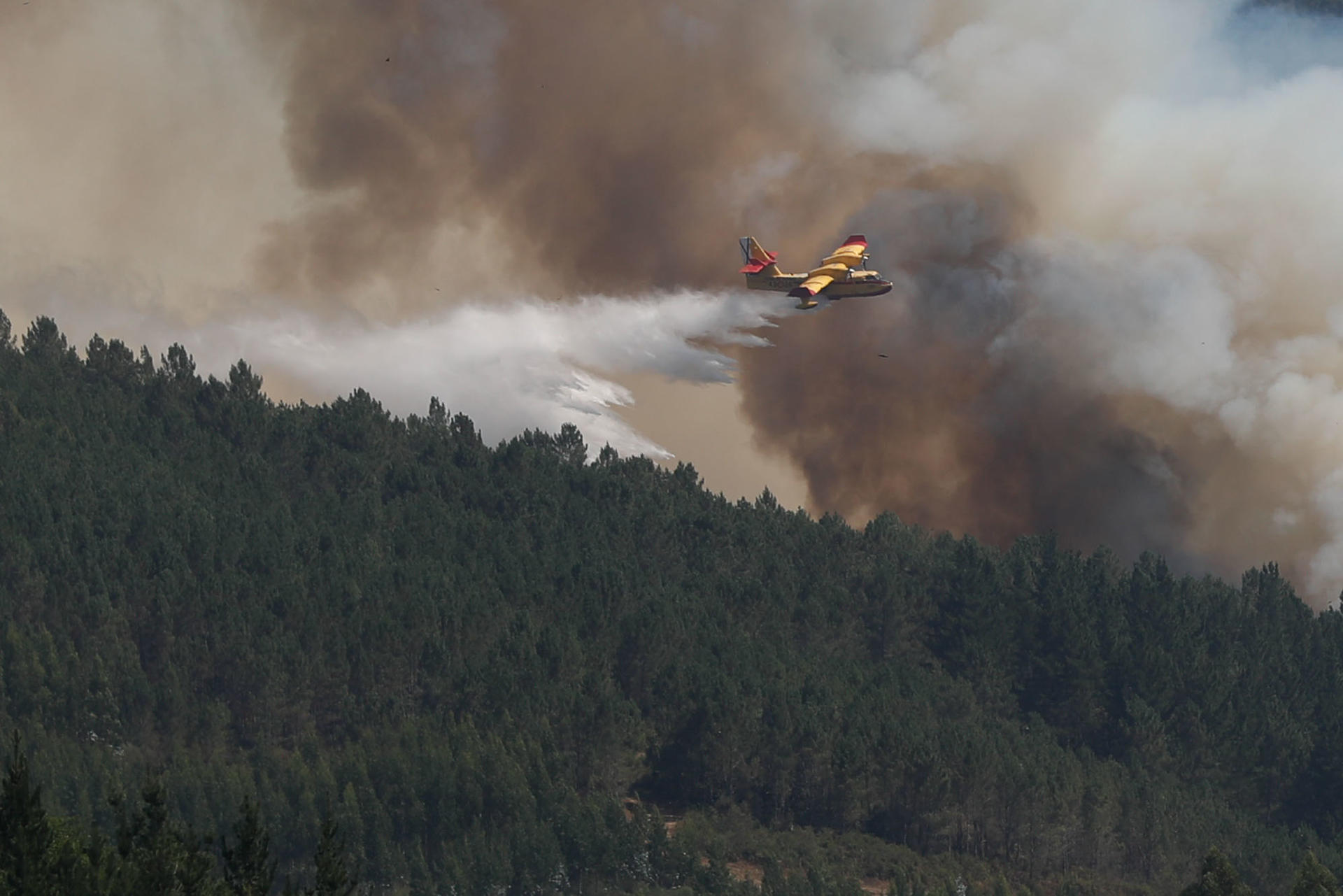 Un hidroavión arroja agua sobre el incendio en la parroquia de Cuiña, perteneciente al municipio lucense de Fonsagrada, este miércoles. EFE/ Eliseo Trigo