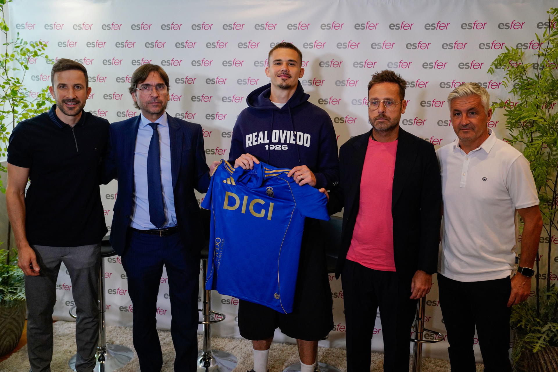 El belga Leander Dendoncker (c) durante su presentación este jueves como nuevo jugador del Real Oviedo en presencia de Arturo Estévez (2i), director general, y David Estévez (2d), director financiero de ESFER, entre otros asistentes. EFE/Paco Paredes
