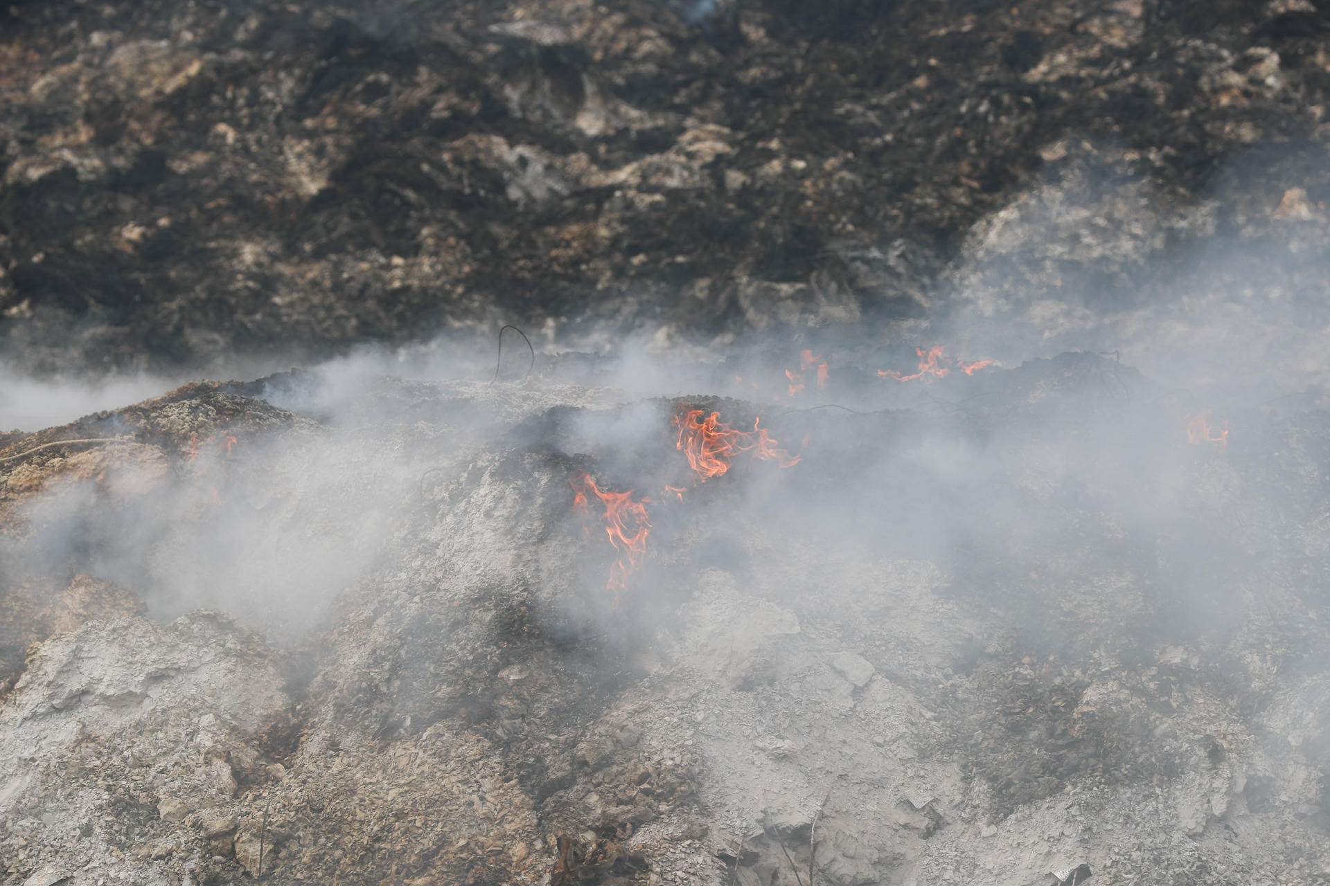 El vertedero de inertes de A Rúa (Ourense) sigue ardiendo tras más de una semana y extiende una nube tóxica sobre Valdeorras. EFE/ Eliseo Trigo