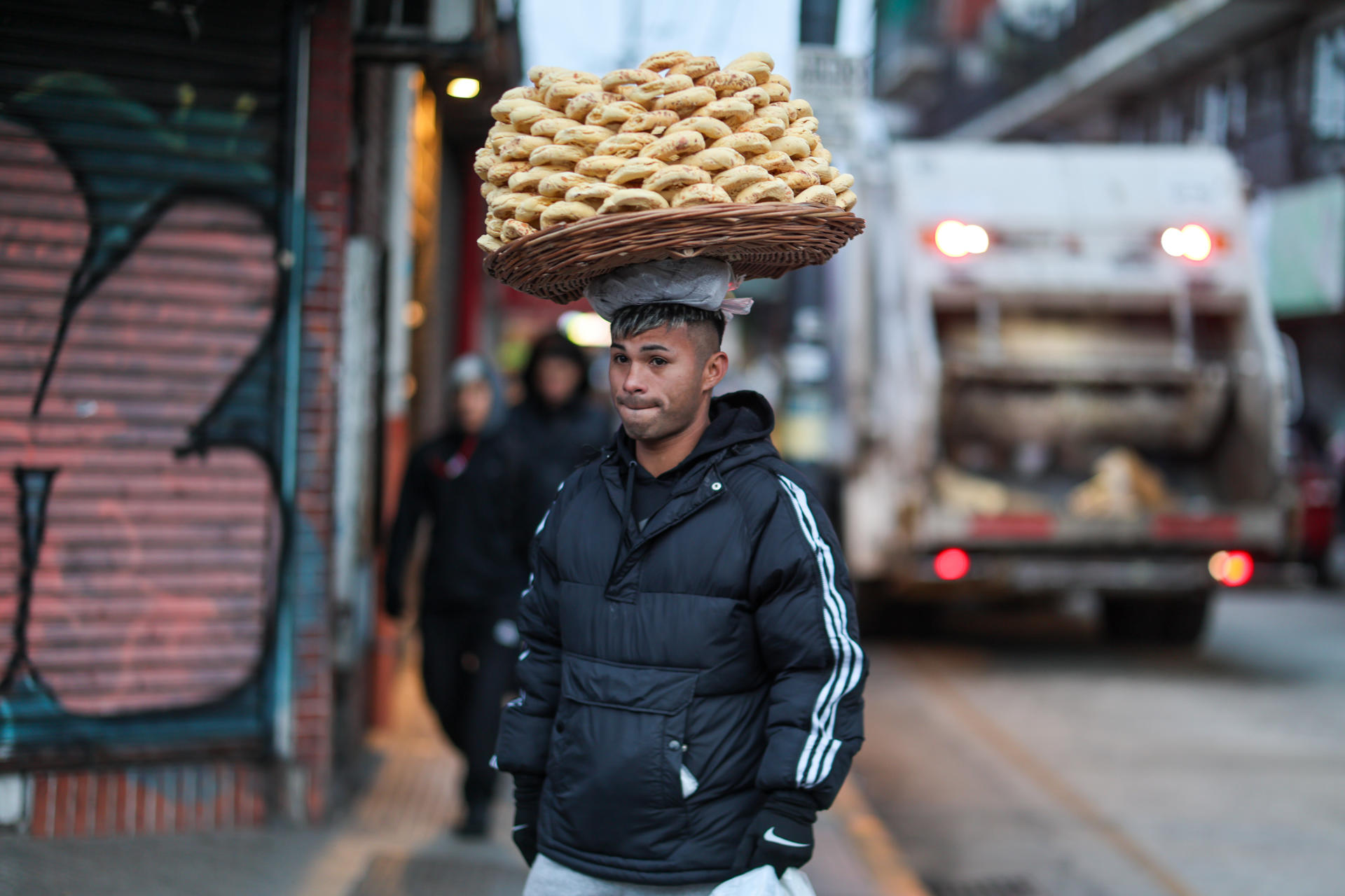Un hombre vende alimentos que sostiene en su cabeza este jueves, en Buenos Aires (Argentina). EFE/ Juan Ignacio Roncoroni
