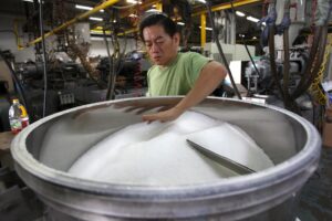 En la imagen de archivo, un trabajador prepara el polipropileno o resina plástica (materia prima de los contenedores de plástico) en una máquina para modelar este material en una fábrica de bolsas en Singapur. EFE/How Hwee Young