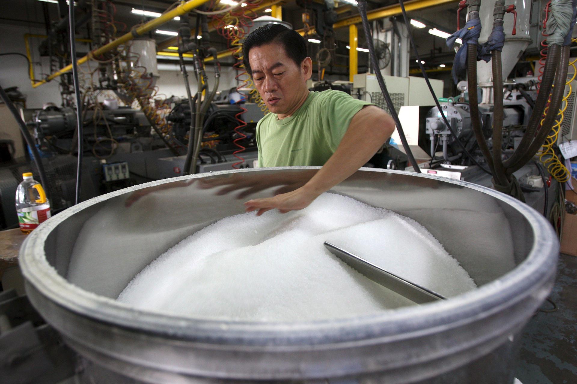 En la imagen de archivo, un trabajador prepara el polipropileno o resina plástica (materia prima de los contenedores de plástico) en una máquina para modelar este material en una fábrica de bolsas en Singapur. EFE/How Hwee Young
