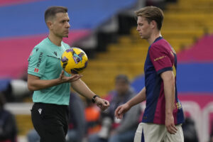 El árbitro Adrián Cordero Vega (i) junto al centrocampista del FC Barcelona Frenkie De Jong (d), durante un partido de la pasada Liga. EFE/Enric Fontcuberta