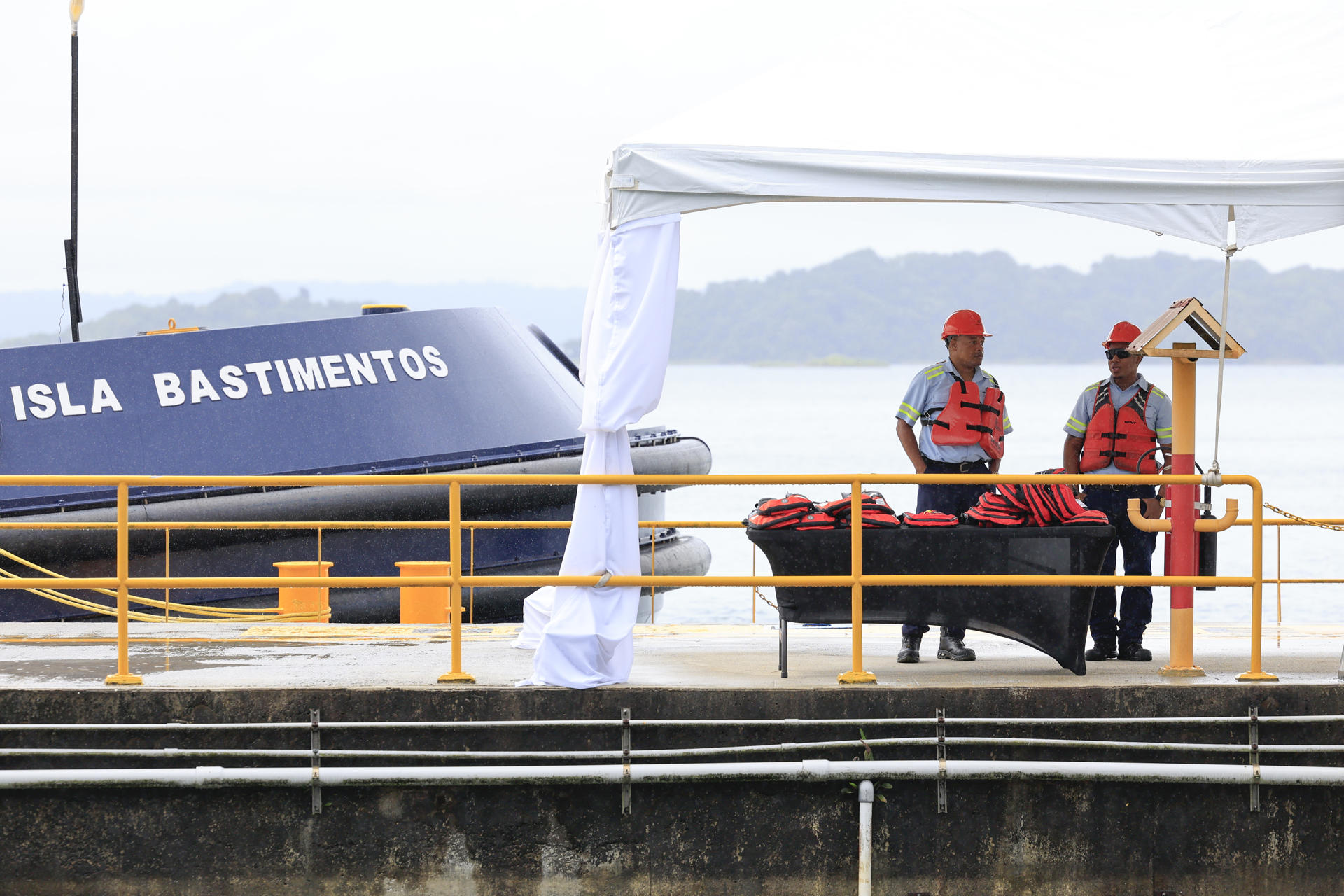 Funcionarios esperan junto al remolcador 'Isla Bastimentos' durante una ceremonia institucional este viernes, en un muelle del Canal de Panamá, en Ciudad de Panamá (Panamá). EFE/ Bienvenido Velasco
