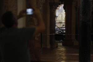Un turista fotografía la zona acotada y afectada en la Mezquita-Catedral después del incendio declarado el pasado viernes en una de las capillas, este lunes en el que la Policía Científica de la Policía Nacional, arquitectos y técnicos inspeccionan las zonas dañadas. EFE/Salas