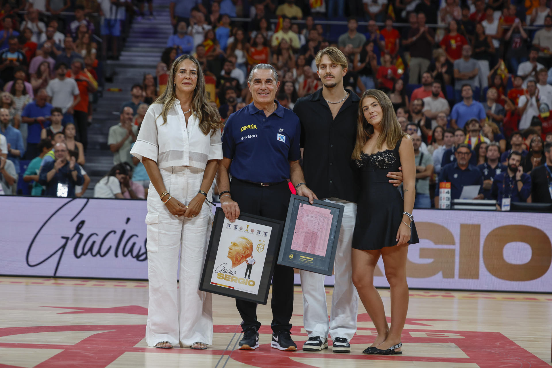 El entrenador de la selección española de baloncesto, Sergio Scariolo (2-i), posa con su familia durante el homenaje recibido al término del partido amistoso ante Alemania disputado este jueves en el Madrid Arena. EFE/Mariscal
