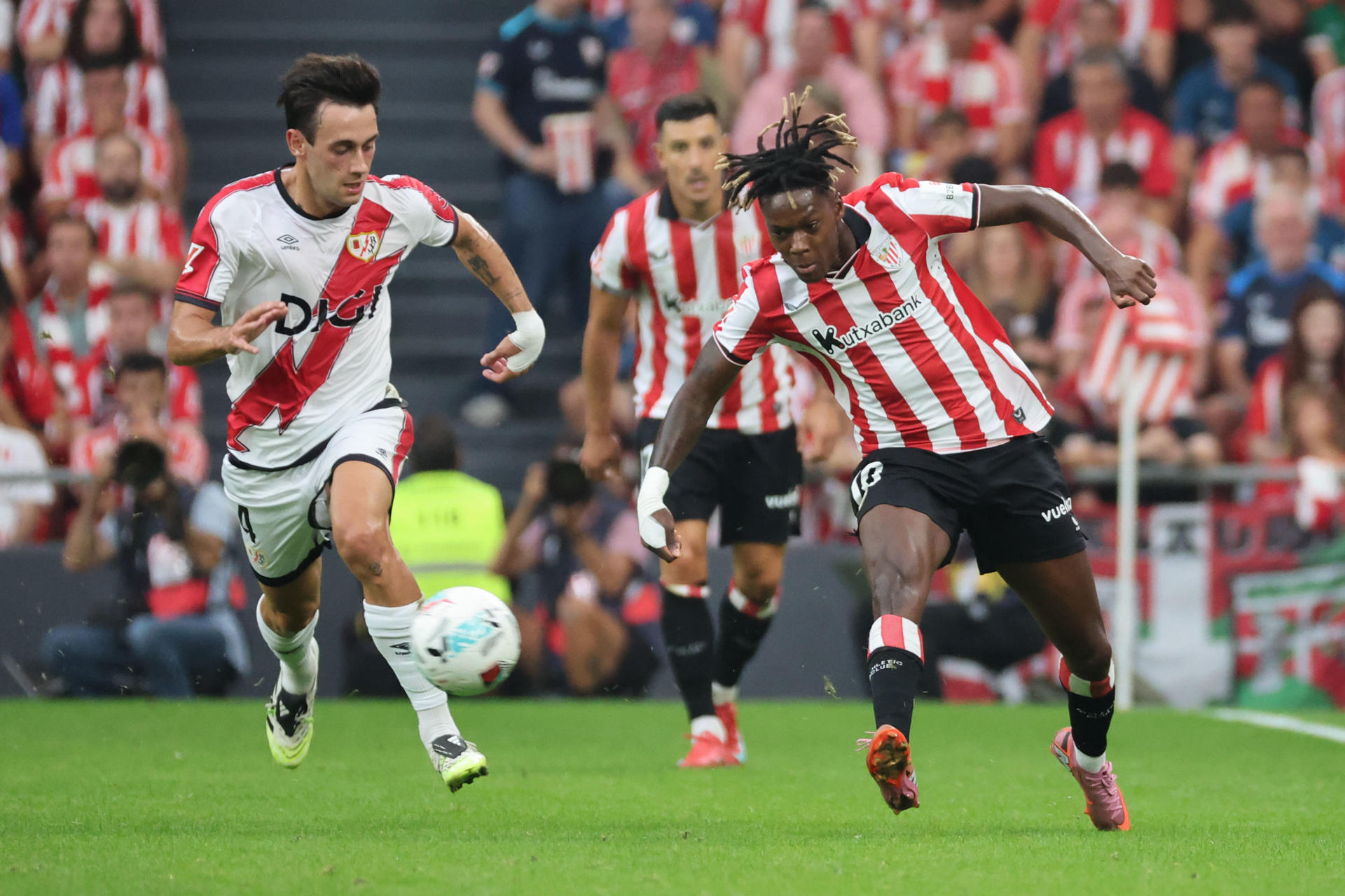 El delantero del Athletic Club Nico Williams (d), pelea una posesión con el centrocampista del Rayo, Pedro Díaz, durante el encuentro correspondiente a la segunda jornada de LaLiga EA Sports disputado entre el Athletic Club y el Rayo Vallecano en San Mamés, este lunes. EFE/ Luis Tejido
