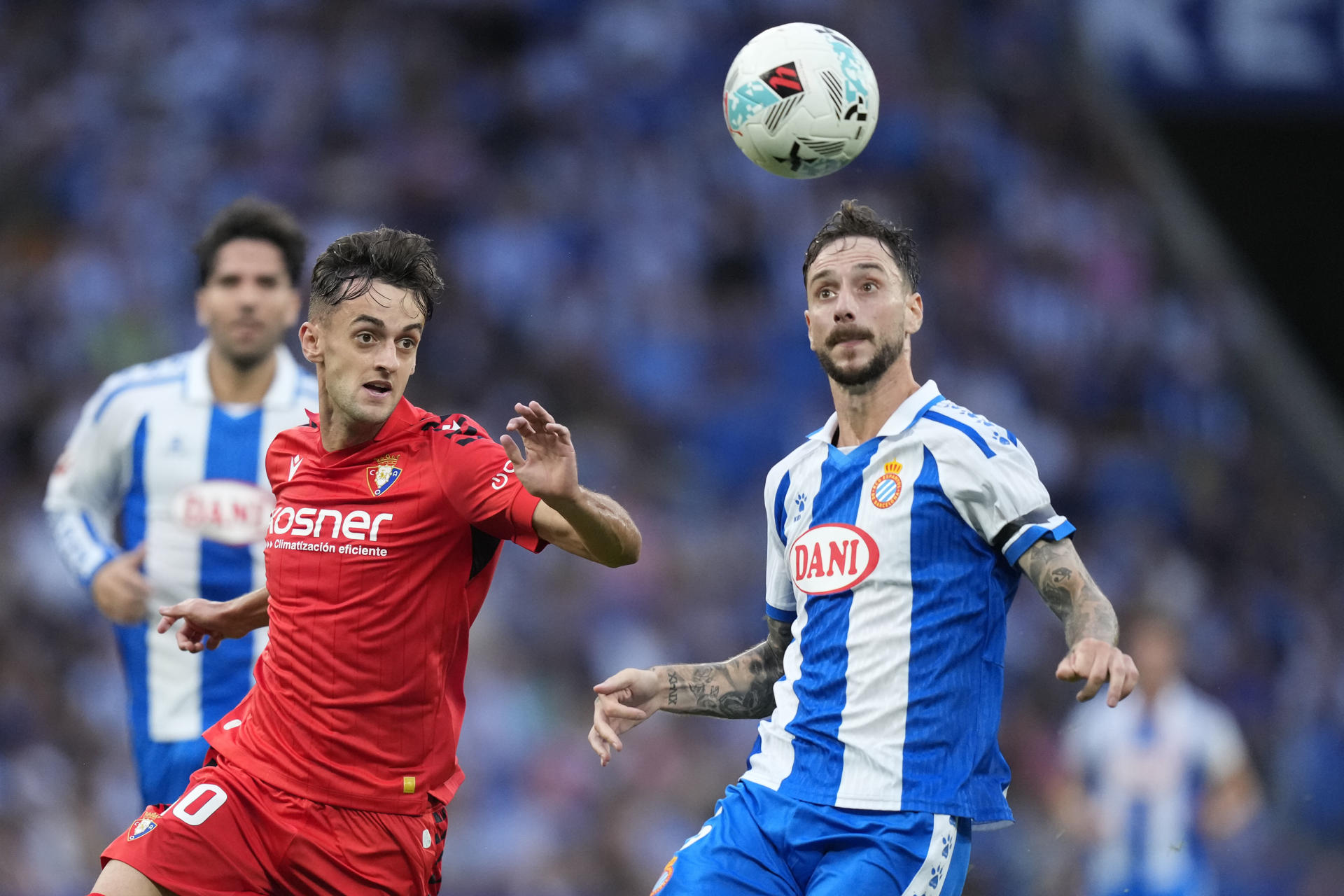 El defensa del Espanyol Fernando Calero (d) lucha con Aimar Oroz, de Osasuna, durante el partido de la tercera jornada de LaLiga que RCD Espanyol y Atlético Osasuna juegan en el RCDE Stadium. EFE/Enric Fontcuberta