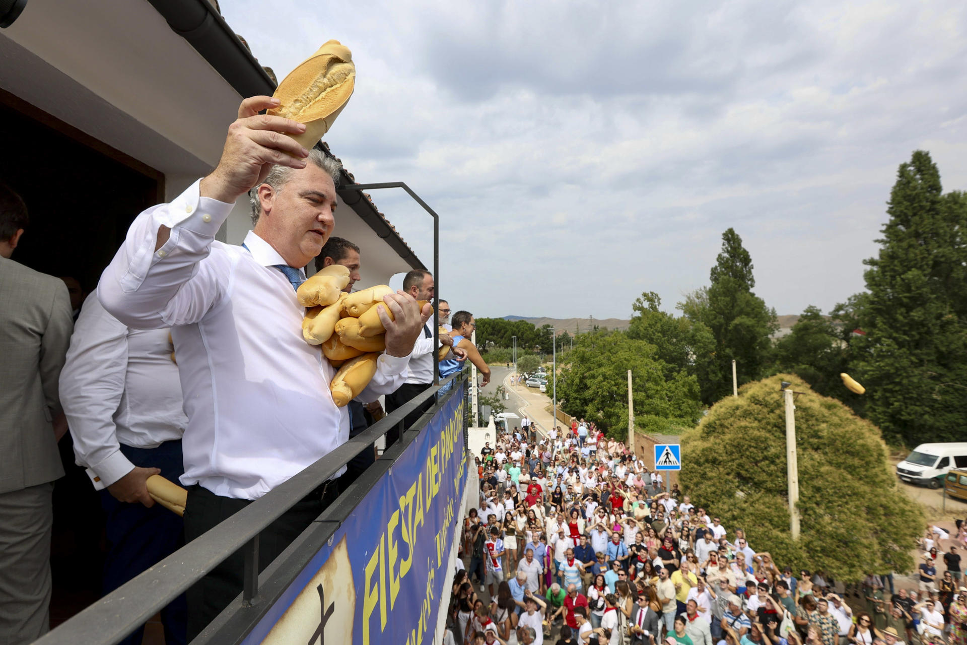 Unas 2.000 personas se han congregado este miércoles frente a la ermita de la Santa Cruz de Quel para conseguir los 2.500 bollos de pan y 60 kilos de queso de Roncal troceado en porciones que les han lanzado para revivir, como cada 6 de agosto, una tradición que data de 1479. EFE/ Raquel Manzanares