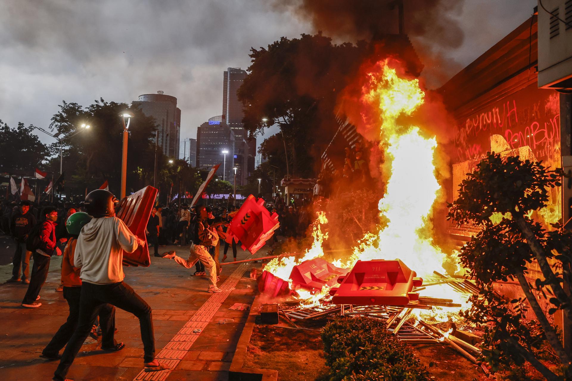 Un grupo de manifestante fue captado este viernes, 29 de agosto, al quemar barreras viales, durante una protesta frente a la sede de la policía de Yakarta, en la capital de Indonesia. EFE/Mast Irham