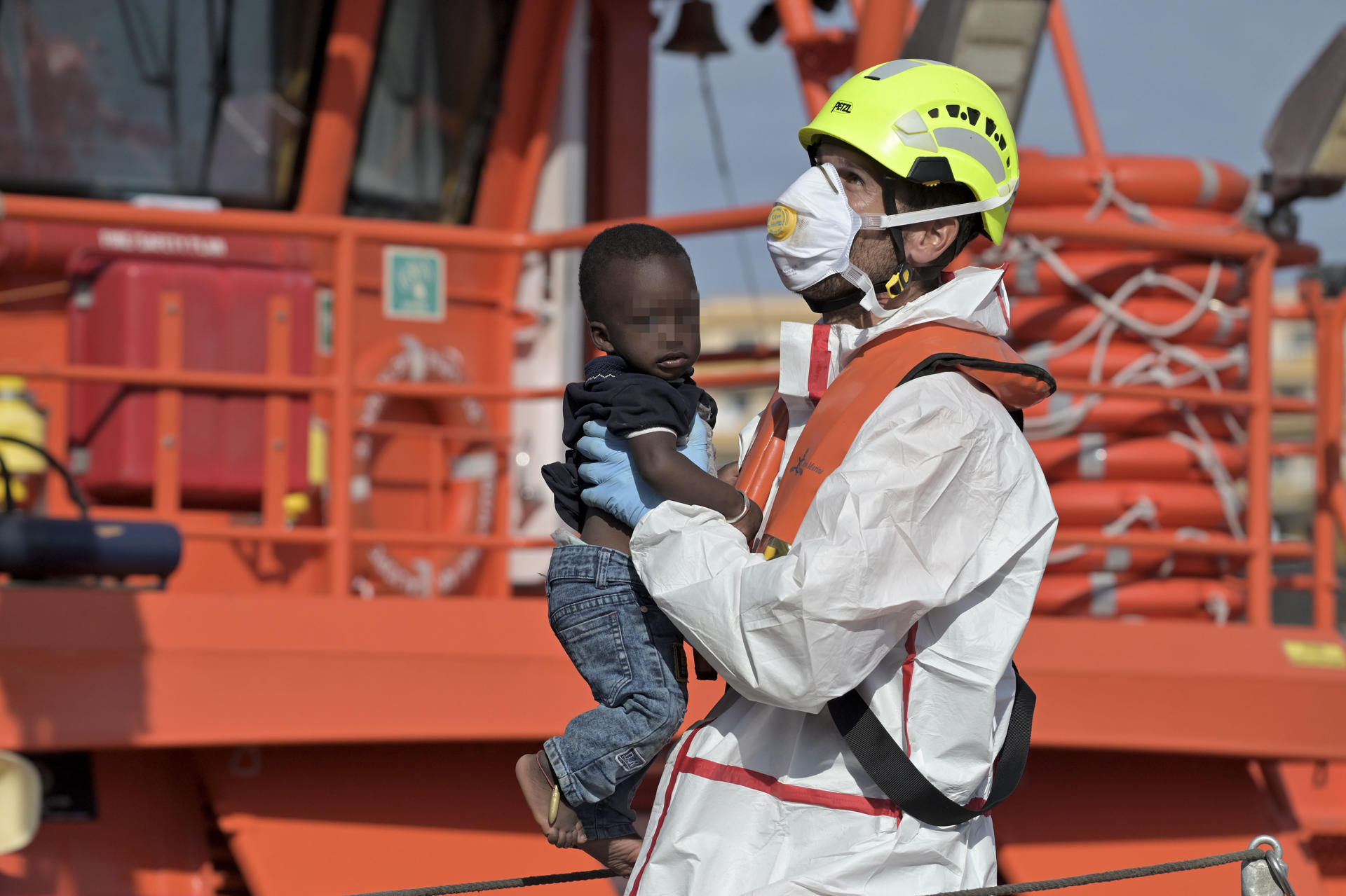 Imagen de archivo de un miembro de Salvamento Marítimo con un niño en brazos tras llegar en un cayuco al puerto de La Restinga. EFE/Gelmert Finol