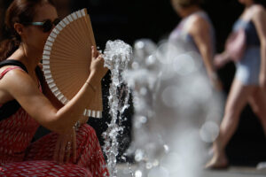 Una mujer se abanica en una calle de Córdoba este viernes, jornada marcada por las altas temperaturas. EFE/Salas