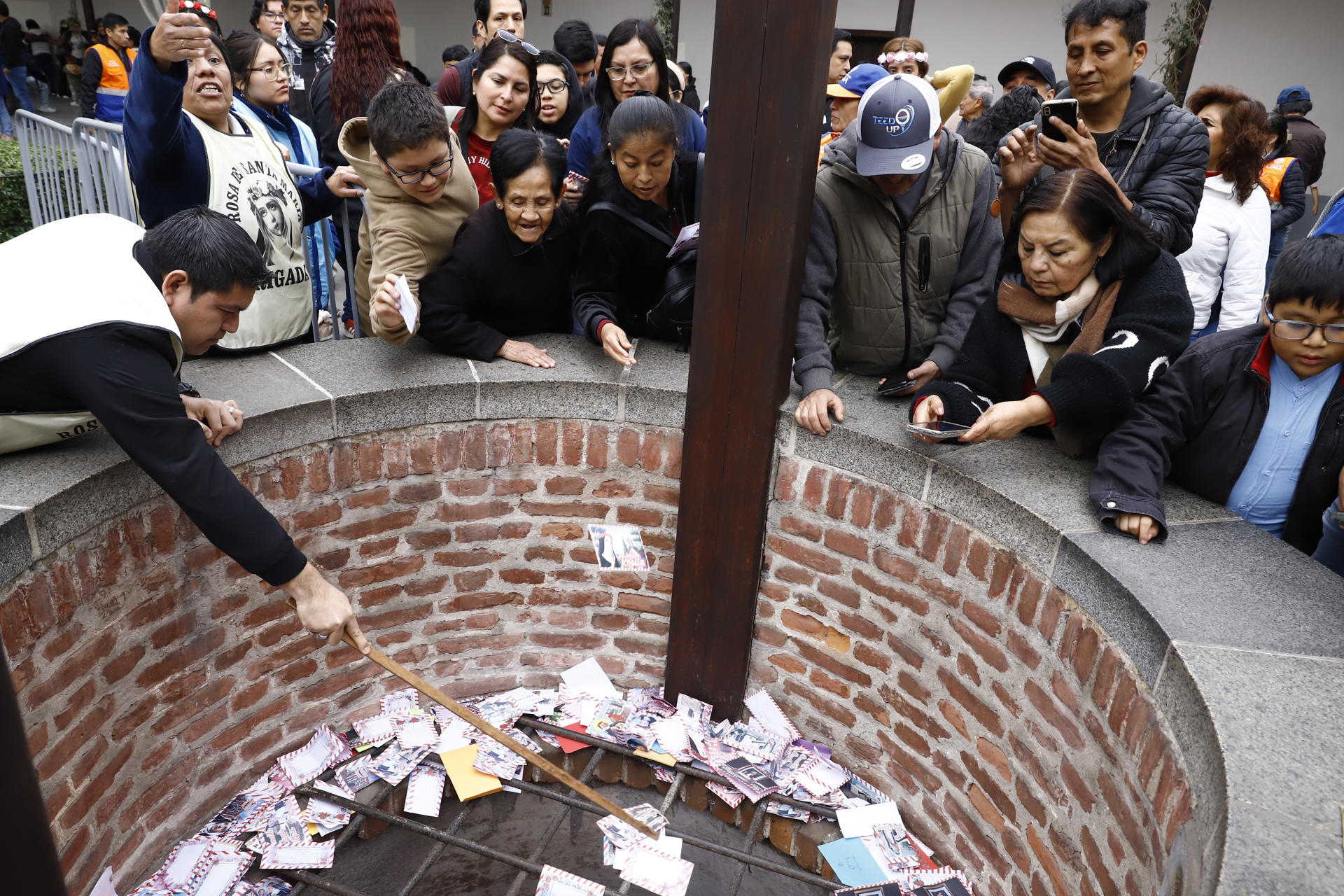Devotos depositan cartas con deseos y plegarias en el pozo de los deseos del Santuario de Santa Rosa de Lima este sábado, en el centro histórico de Lima (Perú). EFE/Sebastian Blanco Salazar