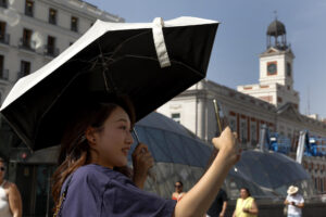 Turistas en la Puerta del Sol en Madrid este miércoles. La persistente ola de calor que mantiene en vilo a España alcanza este miércoles el 'ecuador' de este episodio térmico, con un ligero alivio en las temperaturas en gran parte del territorio.-EFE/Chema Moya