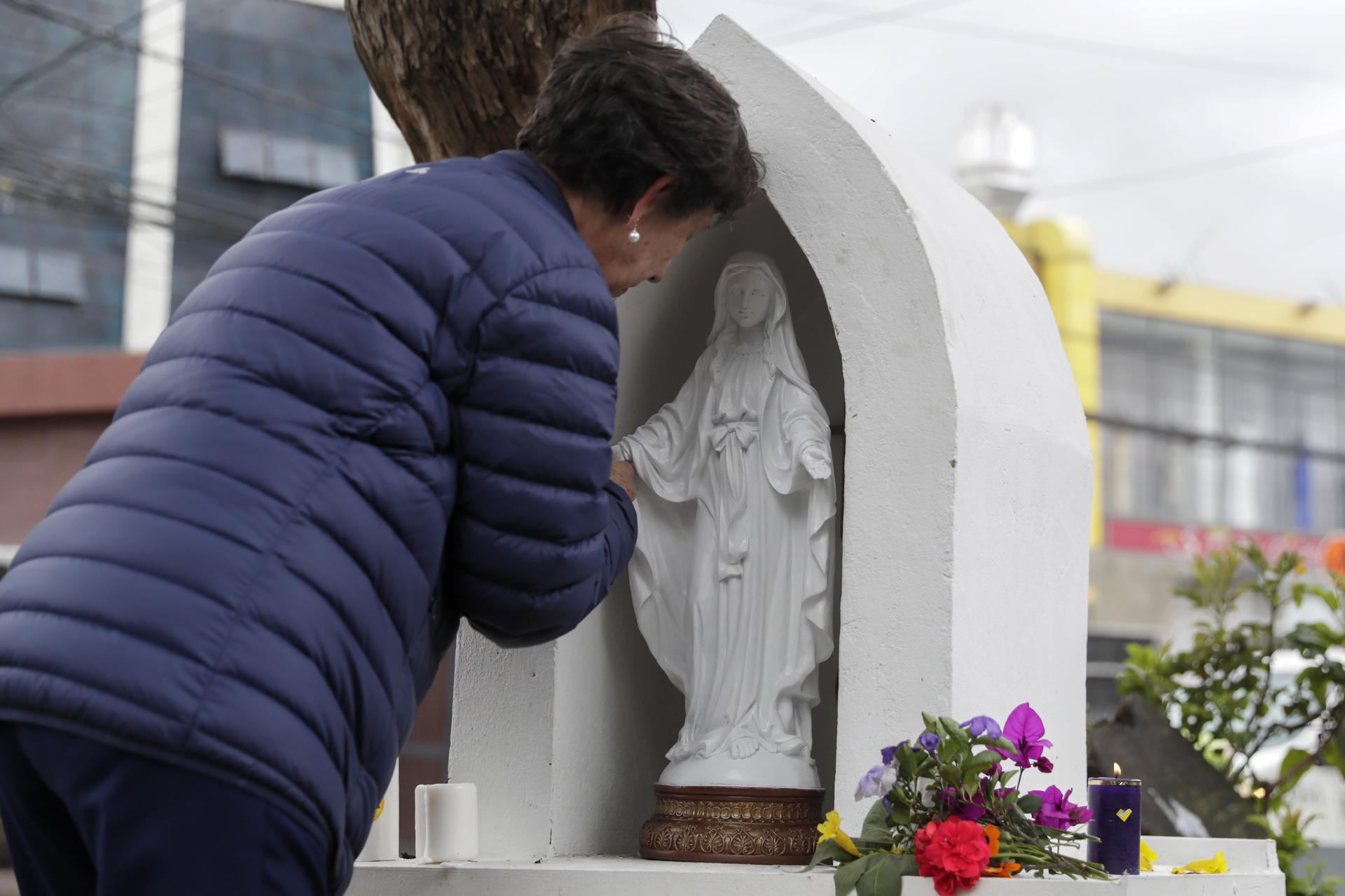 Una persona ora frente a un altar ubicado en el parque El Golfito del barrio Modelia, lugar del atentado contra el senador y precandidato presidencial Miguel Uribe Turbay, este lunes en Bogotá (Colombia). EFE/ Carlos Ortega
