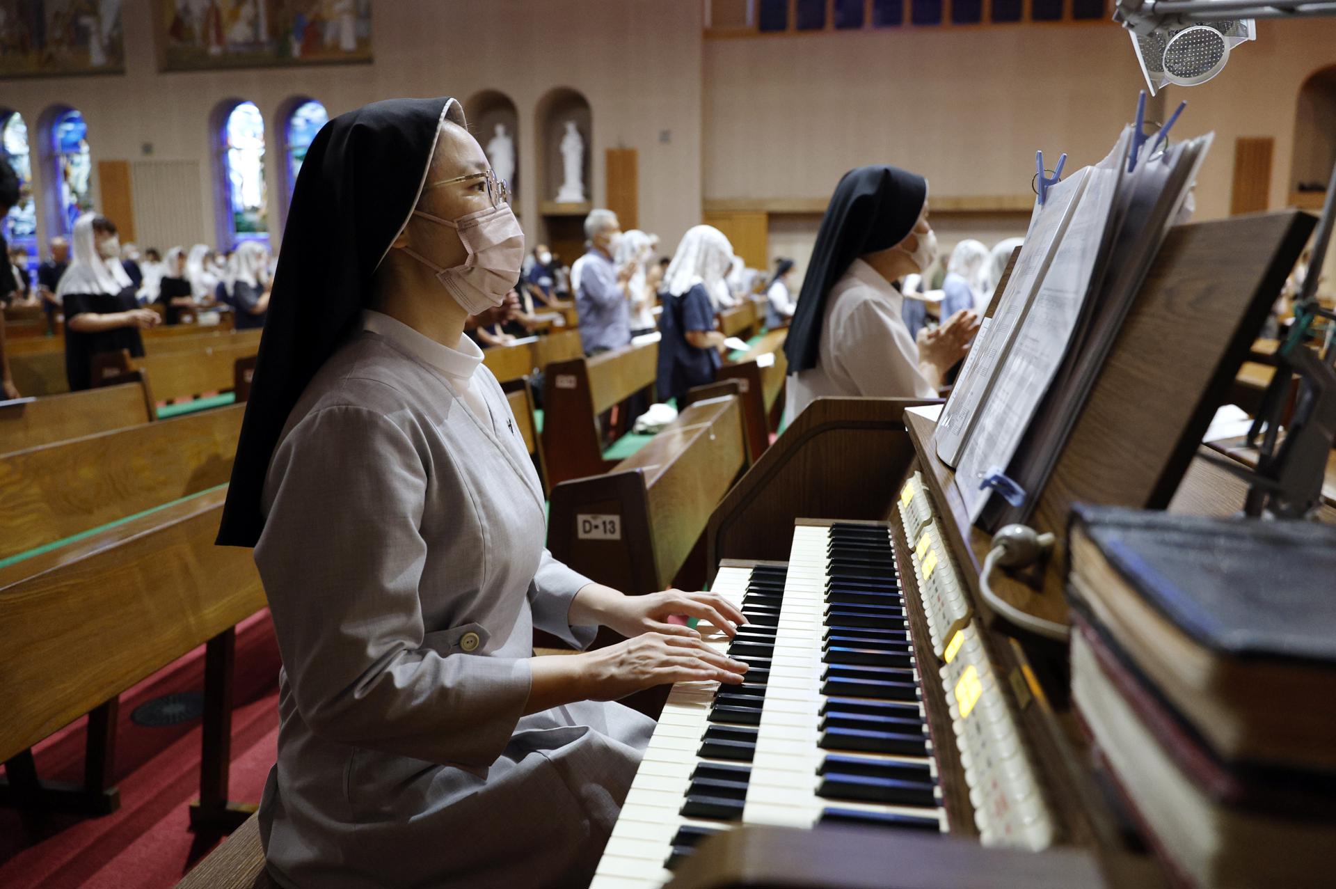Una religiosa toca el órgano durante una misa matutina en la Catedral de Urakami en Nagasaki, Japón, el 9 de agosto de 2025, día del 80.º aniversario del bombardeo atómico. EFE/EPA/FRANCK ROBICHON